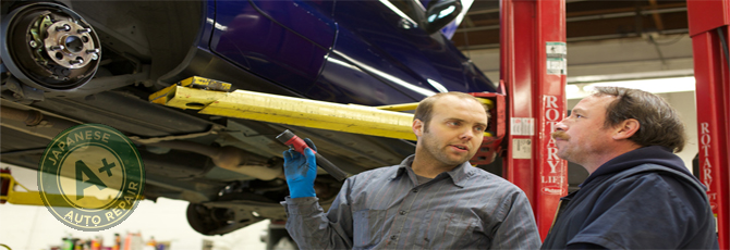 Two mechanics discussing a vehicle on a lift.